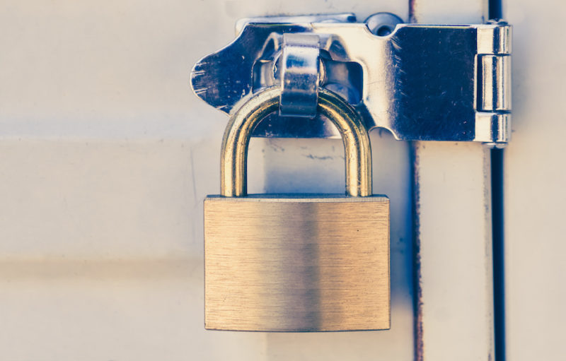 Close – up Metal padlock and metal white door Eviction Legal Services